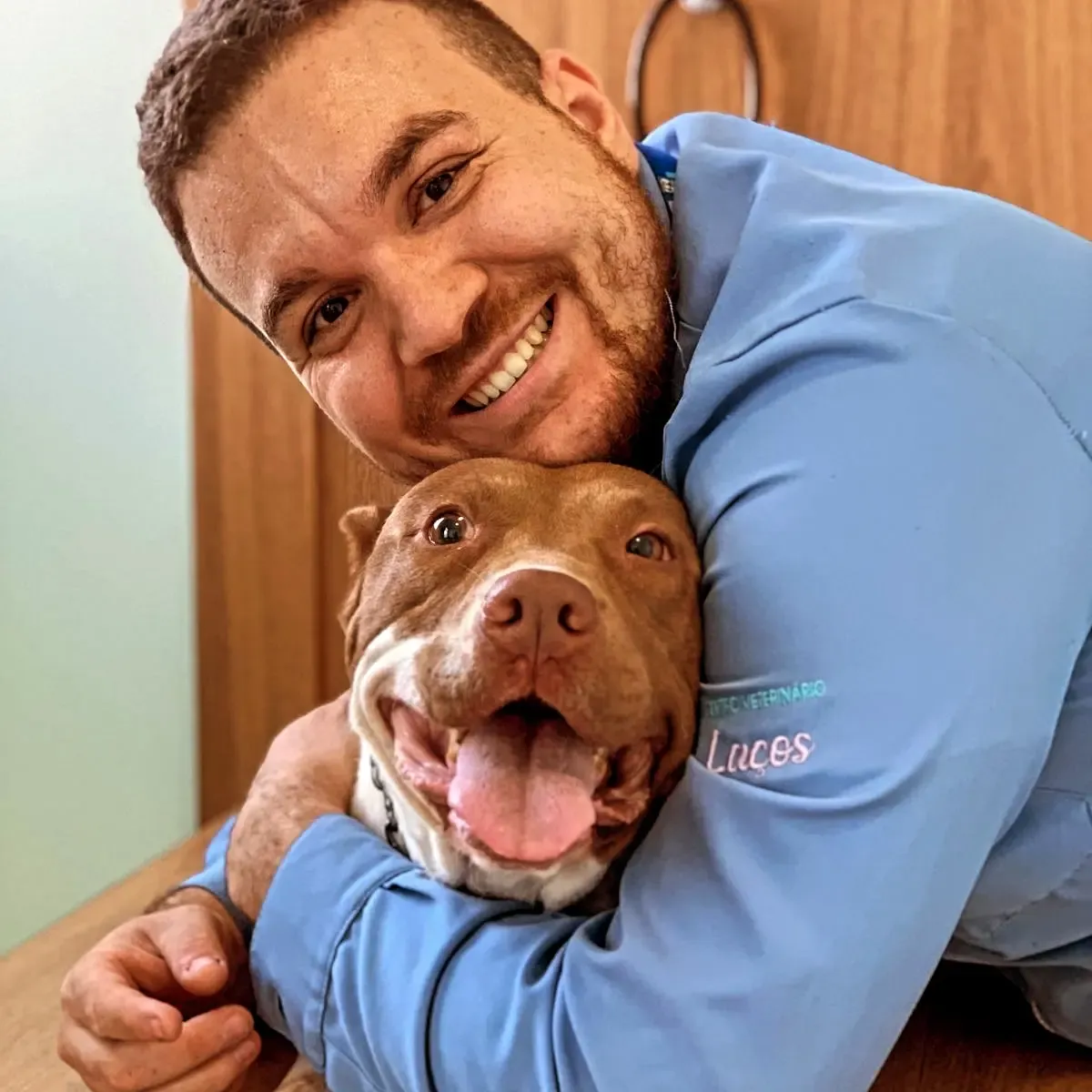 Victor Costa abraçando um cachorro sorridente